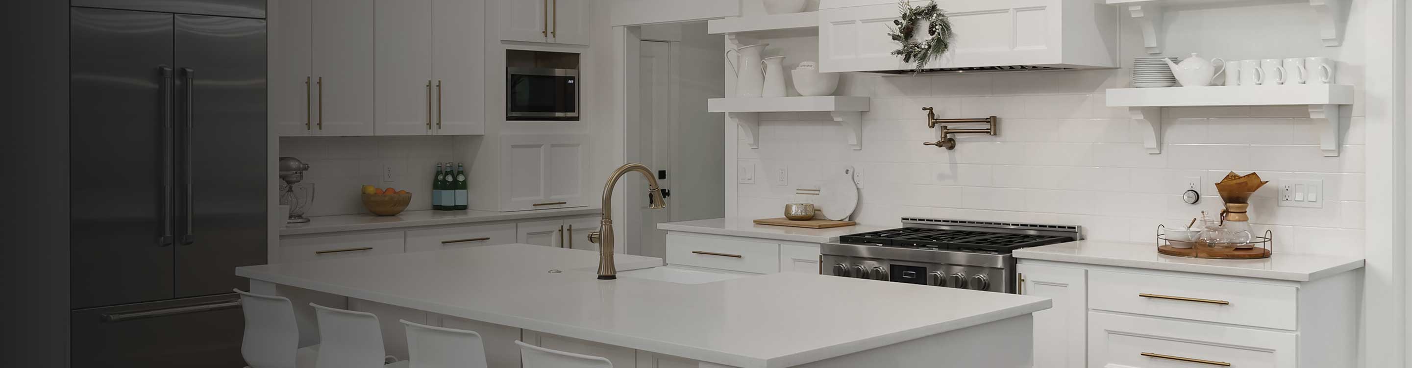 White tile backsplash in a kitchen with white cabinetry and countertops